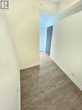 Barrie (City Centre) condo for rent - A hallway with wood flooring and white walls.