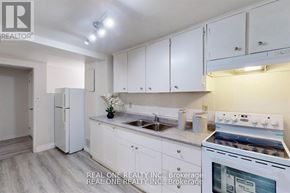 Aurora (Aurora Heights) apartment for rent - A white kitchen with a stove, sink, and cabinets.