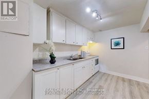 Aurora (Aurora Heights) apartment for rent - A kitchen with white cabinets and a vase of white flowers on the counter.