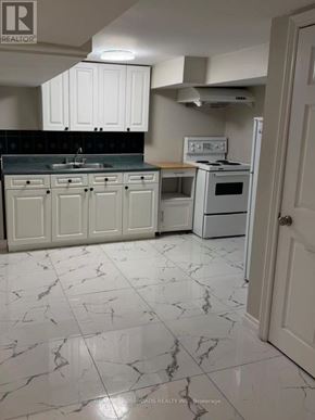 Toronto (Wexford-Maryvale) apartment for rent - A kitchen with white cabinets and marble flooring.