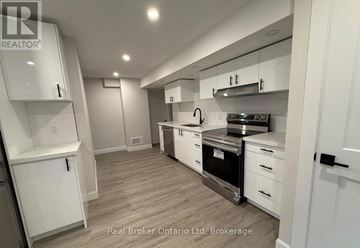 Barrie (Georgian Drive) apartment for rent - A modern kitchen with white cabinets and stainless steel appliances.