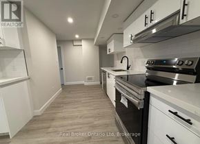 Barrie (Georgian Drive) apartment for rent - A kitchen with white cabinets and a stainless steel oven.
