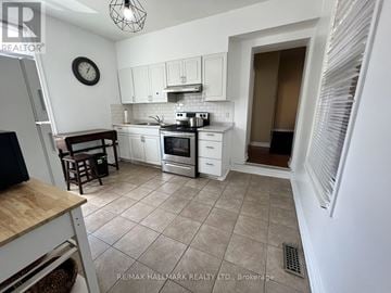 Toronto (Moss Park) duplex for rent - A kitchen with white cabinets and a tile floor.