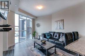 Grimsby (Grimsby Beach) condo for rent - A living room with a black leather couch and a flat screen TV mounted on the wall.