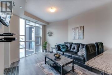 Grimsby (Grimsby Beach) condo for rent - A living room with a black leather couch and a flat screen TV mounted on the wall.