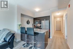 Grimsby (Grimsby Beach) condo for rent - A modern kitchen with a bar stool and a black leather sofa.