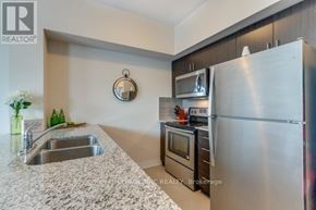 Grimsby (Grimsby Beach) condo for rent - A kitchen with a stainless steel refrigerator, microwave, and oven.