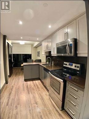 Waterloo condo for rent - A modern kitchen with a stove top oven and microwave.