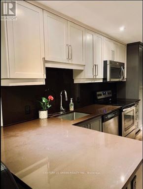 Waterloo condo for rent - A kitchen with white cabinets and black appliances.