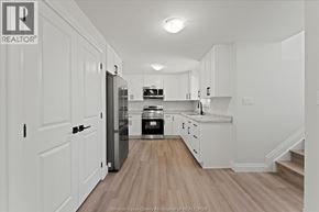 Windsor apartment for rent - A kitchen with white cabinets and a wooden floor.