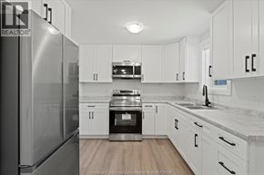 Windsor apartment for rent - A kitchen with white cabinets and a stainless steel refrigerator.