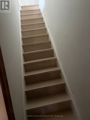 Toronto (Danforth) apartment for rent - A staircase with beige steps and white walls.