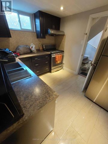 Toronto (Woburn) apartment for rent - A kitchen with black cabinets and a granite countertop.