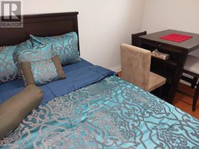 Toronto (Woburn) apartment for rent - A bed with blue bedding and a brown headboard is in the image.