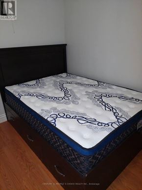Toronto (Woburn) apartment for rent - A mattress with a blue and white pattern is on a wooden floor.