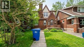 Windsor apartment for rent - A blue trash bin sits on a grassy lawn in front of a house.