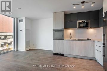 Toronto (Mount Pleasant West) condo for rent - A kitchen with white cabinets and a black countertop.