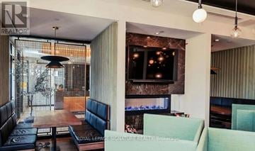 Oakville (Ga Glen Abbey) condo for rent - A modern living room with a television and a fireplace.