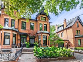 Toronto (Annex) apartment for rent - A large brick house with a black front door and a small garden in front.