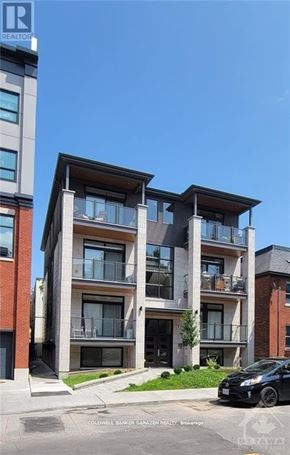 Ottawa apartment for rent - A modern apartment building with a black car parked in front.