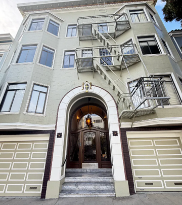 San Francisco apartment for rent - A building with a staircase on the side and a garage door.