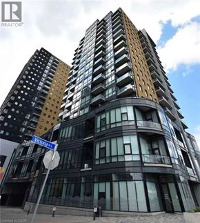Kitchener condo for rent - A tall building with a curved design and a sign that says Victoria St.