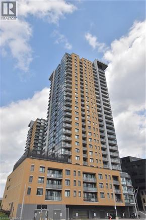 Kitchener condo for rent - A tall building with a glass facade topped with a triangular section.