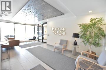 Kitchener condo for rent - A living room with a grey carpet and wooden furniture.