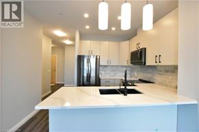 Kitchener condo for rent - A modern kitchen with a white countertop and a black sink.