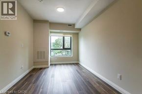 Waterloo condo for rent - A spacious room with wooden floors and a large window.