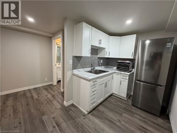 Kitchener apartment for rent - A kitchen with white cabinets and a stainless steel refrigerator.