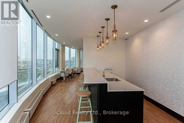 Mississauga (Central Erin Mills) condo for rent - A modern kitchen with a long counter and bar stools.