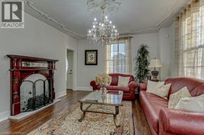 Scotland apartment for rent - A living room with a red couch, a fireplace, and a chandelier.