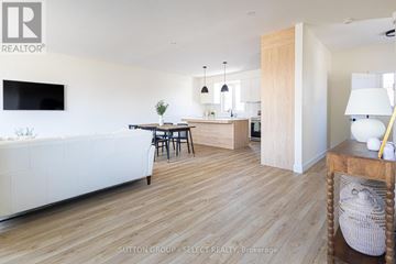 Thames Centre (Thorndale) townhouse for rent - A living room with a white couch and a television on the wall.