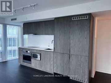 Toronto (Church-Yonge Corridor) condo for rent - A modern kitchen with wooden cabinets and a stainless steel oven.
