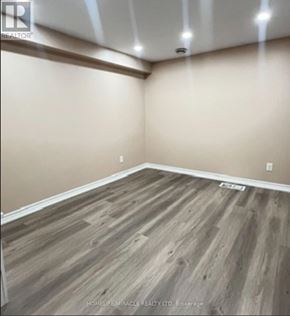 Toronto (Rouge) townhouse for rent - A room with wooden flooring and a ceiling with lights.