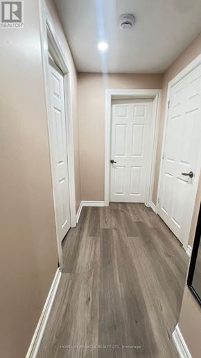Toronto (Rouge) townhouse for rent - A hallway with white doors and a wooden floor.
