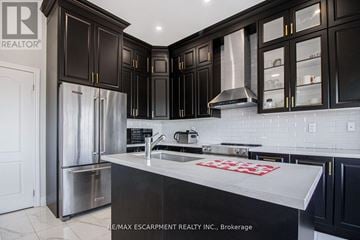 Oshawa (Mclaughlin) apartment for rent - A kitchen with black cabinets and a white counter top.