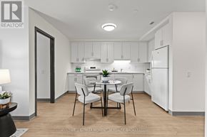 Thorold (Thorold Downtown) multi-family for rent - A modern kitchen with white cabinets and a dining table set for two.