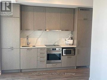 Vaughan (Concord) condo for rent - A kitchen with beige cabinets and a stainless steel oven.