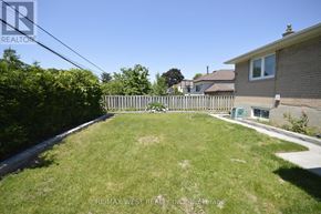 Toronto (West Humber-Clairville) apartment for rent - A backyard with a fence and a house in the background.