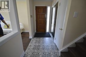 Toronto (West Humber-Clairville) apartment for rent - A hallway with a patterned rug and a wooden door.