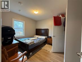Windsor apartment for rent - A bedroom with a bed, dresser, and chair.