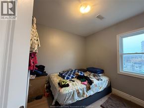 Windsor apartment for rent - A bedroom with a bed, pillows, and a window.
