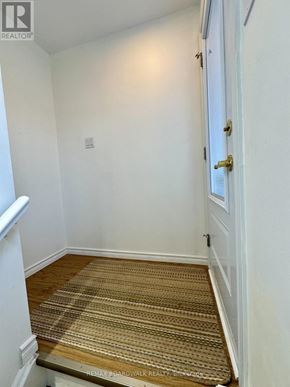 Ottawa apartment for rent - A hallway with a carpeted floor and a white door.
