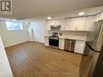 Ottawa apartment for rent - A kitchen with white cabinets and a wooden floor.