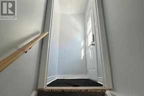 Whitby (Brooklin) apartment for rent - A hallway with a wooden staircase leading to the second floor.