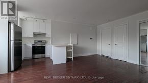 Toronto (East End-Danforth) apartment for rent - A white kitchen with a refrigerator, sink, and cabinets.