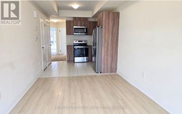Toronto (Malvern) townhouse for rent - A kitchen with a refrigerator, oven, and microwave.