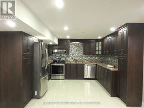 Brampton (Toronto Gore Rural Estate) apartment for rent - A kitchen with dark wood cabinets and stainless steel appliances.